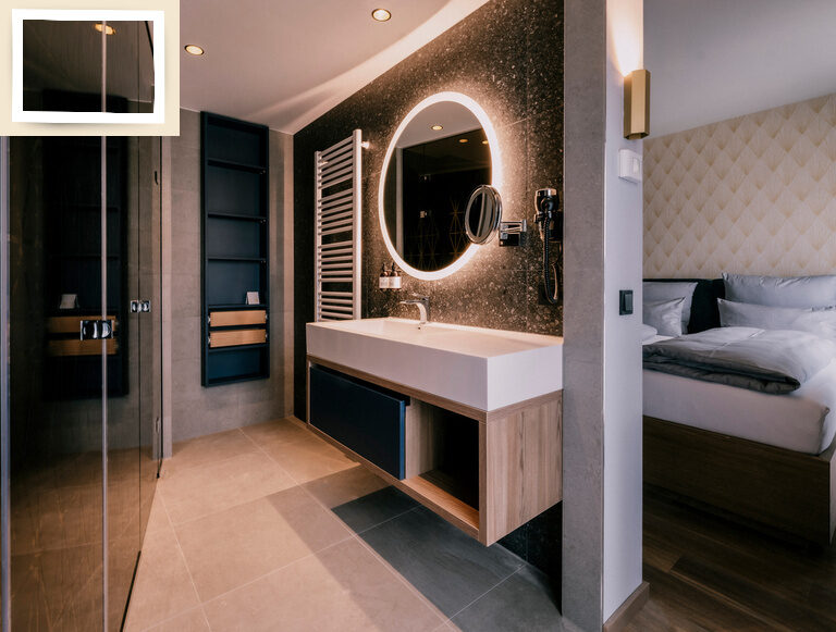 Modernes Bad mit Waschbecken und beleuchtetem Spiegel im Doppelzimmer Premium des Wellnesshotel Holzapfel Bad Füssing.