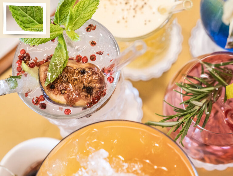 Eine Auswahl an leckeren bunten Cocktails mit frischen Beeren als Garnitur auf einem Tisch.