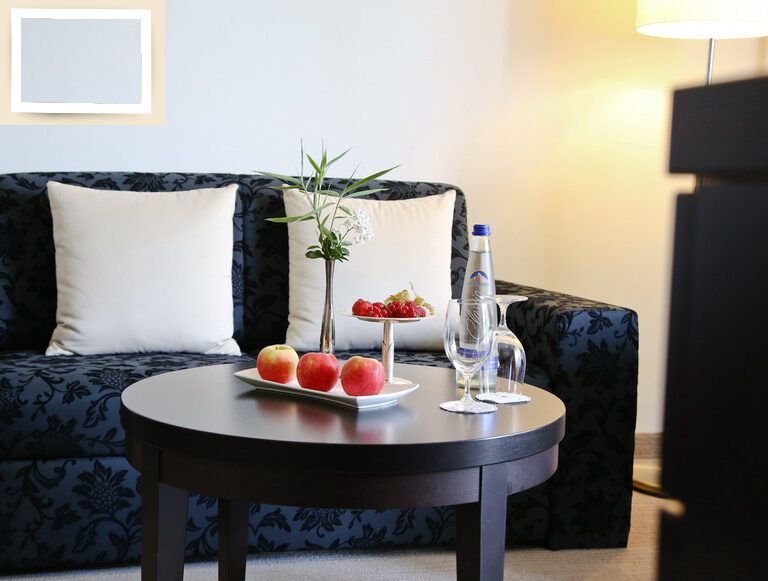 Ein schickes, elegant blumig gemustertes Sofa im gemütlichen Wohnzimmer des Doppelzimmer Deluxe Süd im Thermenhotel Holzapfel bei Passau.