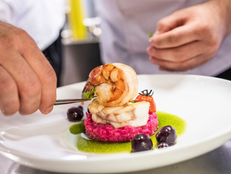 Ein feines Fischgericht garniert mit frischen Beeren im Gesundheitshotel Holzapfel im Rottal.