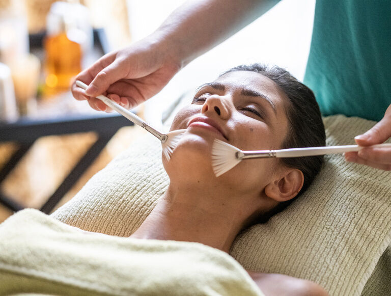 Im Wellnessbereich des Thermenhotels Holzapfel in Bayern erhält eine Frau eine wohltuende Behandlung.