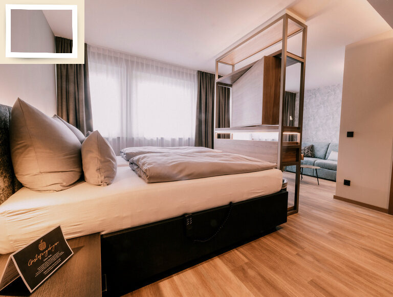 Stilvolle Doppelzimmer Comfort Raumansicht mit gemütlichem Doppelbett und Sitzmöglichkeiten im Wellnesshotel Holzapfel in Bayern.
