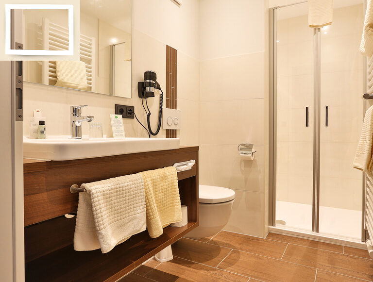 Elegantes Badezimmer mit modernen Armaturen und flauschigen Handtüchern im Thermenhotel Holzapfel, perfekt für Entspannung und Erholung im Einzelzimmer Comfort.