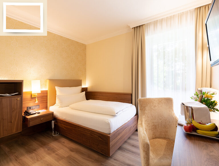 Modernes Einzelzimmer Standard im Wellnesshotel Holzapfel mit einem Bett, Schreibtisch und Fernseher.