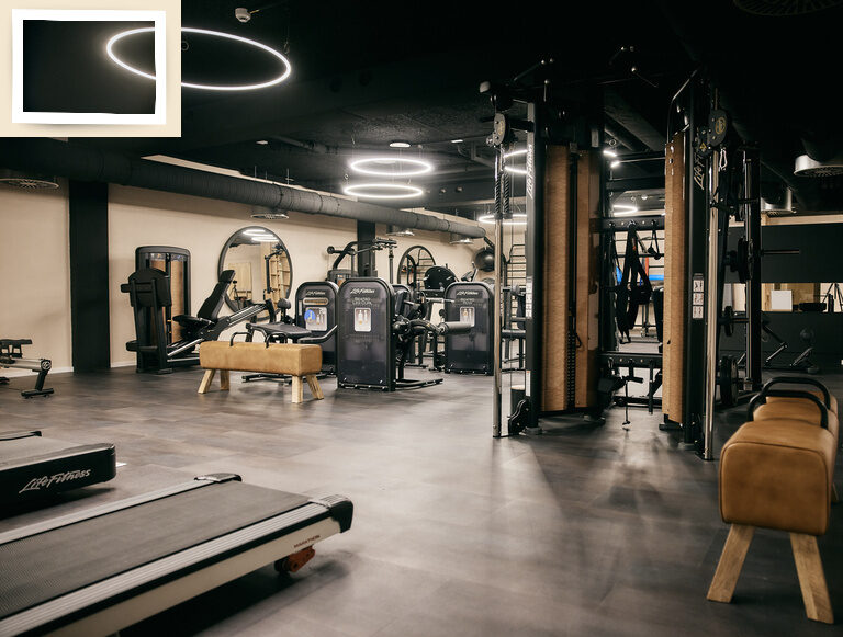 Heller Trainingsraum im Fitnesshotel Holzapfel im Rottal, ausgestattet mit modernen Cardiogeräten und Beleuchtungstechniken.
