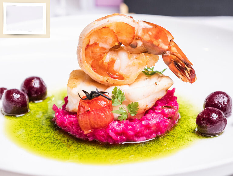 Ein Teller mit Garnelen und Gemüse, kunstvoll angerichtet im Wellneshotel Holzapfel.