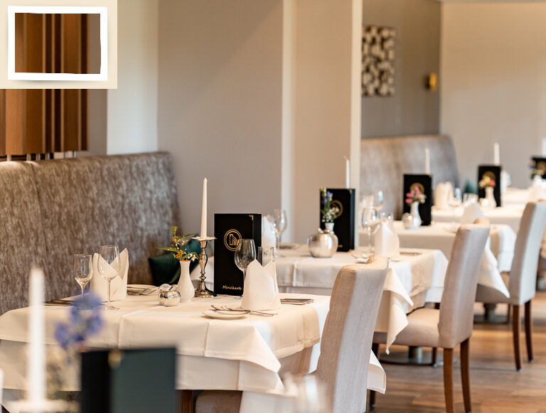 Eine elegante Einrichtung mit weißen Tischdecken und stilvollen Stühlen im Gartenrestaurant im Gesundheitshotel Holzapfel.