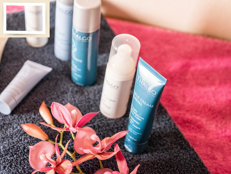 Verschiedene Kosmetikprodukte in Tuben und Flaschen zur persönlichen Pflege aufbereitet auf einem Tisch im Spa-Bereich des Wellnesshotel Holzapfel..