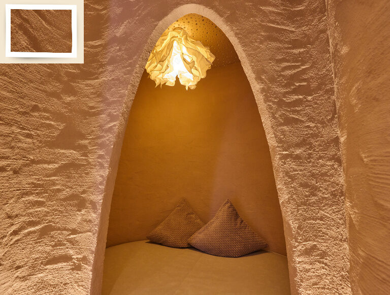 Eine Höhle zum Entspannen mit Kissen und Licht im Wellnessbereich des Hotels Holzapfel