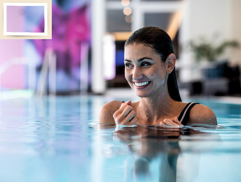 Entspanntes Lächeln einer Frau im modernen Innenpool während eines Hotelaufenthalts im Thermenhotel Holzapfel in Niederbayern.