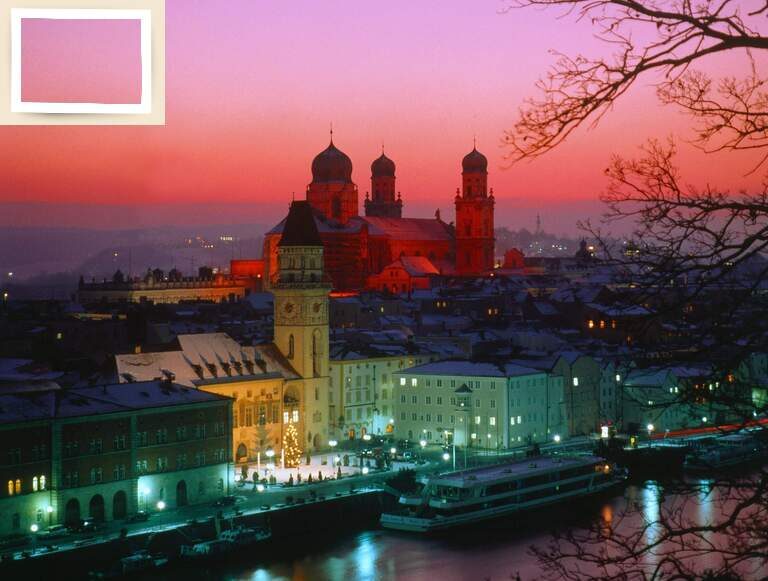 Die majestätischen Türme der Passauer Kirche erheben sich über dem ruhig reflektierenden Fluss bei Nacht.