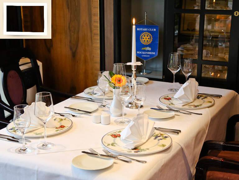 Ein sauber gedeckter Tisch mit Weingläsern und Porzellantellern im Rotary Clubraum in der Nähe des Seminarhotels Holzapfel bei Passau.