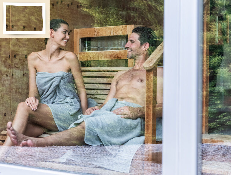 Ein Paar entspannt gemeinsam auf einer gemütlichen Bank in der Spa-Welt des Wellnesshotel Holzapfel in Bayern.