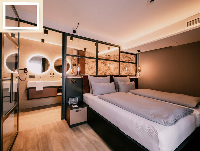 Die luxuriöse Suite Pink Lady im Thermenhotel Holzapfel bietet eine komfortable Übernachtungsmöglichkeit mit gemütlichem Doppelbett Bett und Waschbecken.