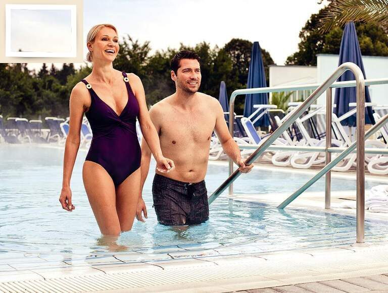 Ein Paar geht lächelnd nach der Entspannung im Schwimmbecken der Therme Eins in Bad Füssing heraus.