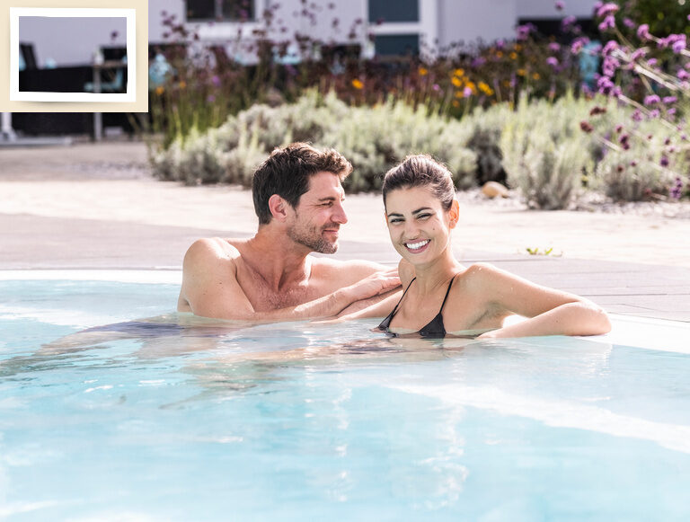 Ein entspanntes Paar im Außenpool des Wellnesshotel Holzapfel genießt die strahlende Sommersonne.