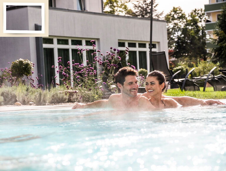 Ein Paar genießt den Außenpool im Thermenhotel Holzapfel.