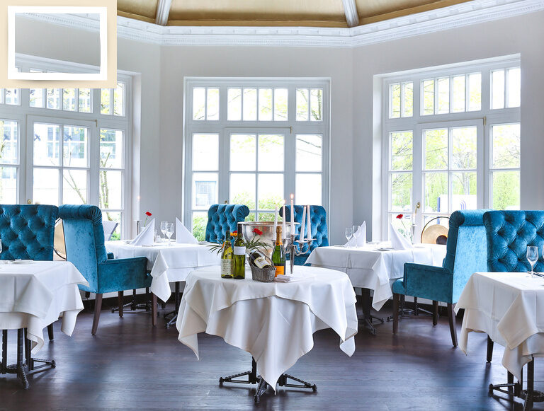 Elegantes Restaurant Glockenturm im Gesundheitshotel Holzapfel bei Bad Füssing mit blauen Stühlen und weiß gedeckten Tischen.