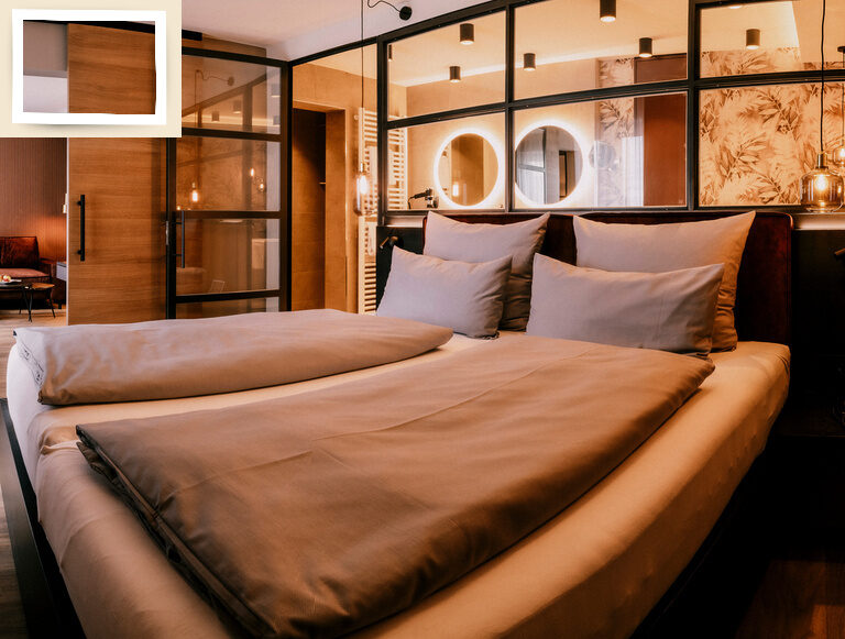 Suite Pink Lady in Thermenhotel Holzapfel in Bayern mit komfortablen Doppelbett und moderner verglasten Innenausstattung.