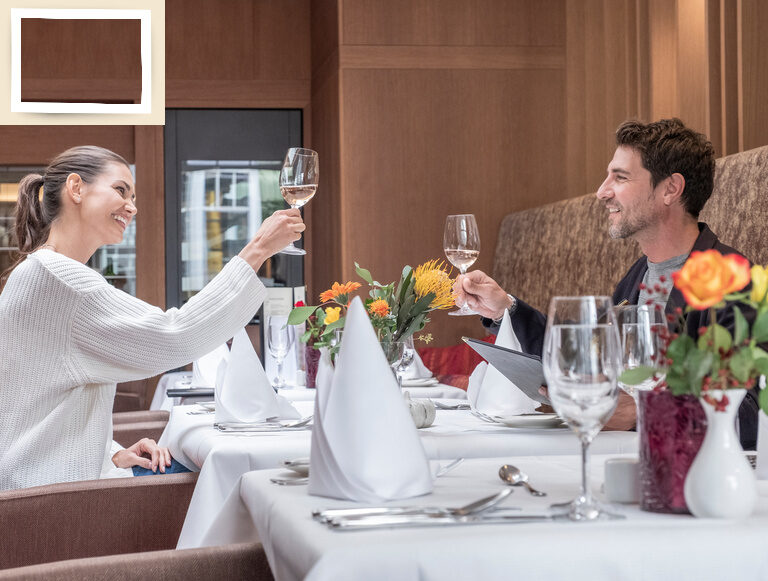 Ein Paar genießt Wein in der eleganten Weinlounge des 4-Sterne-Hotels Holzapfel.
