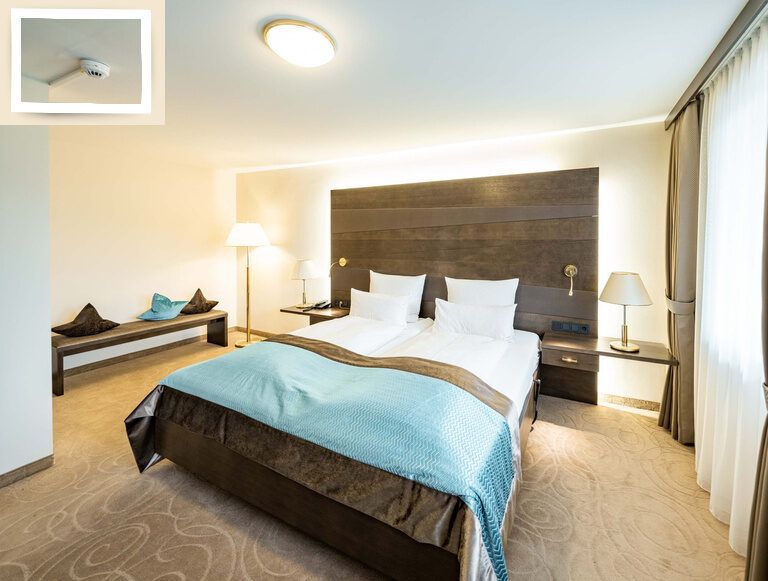 Ein gemütliches Zimmer im Wellnesshotel Holzapfel im Rottal mit einem bequemen Bett und einem funktionalen Schreibtisch.